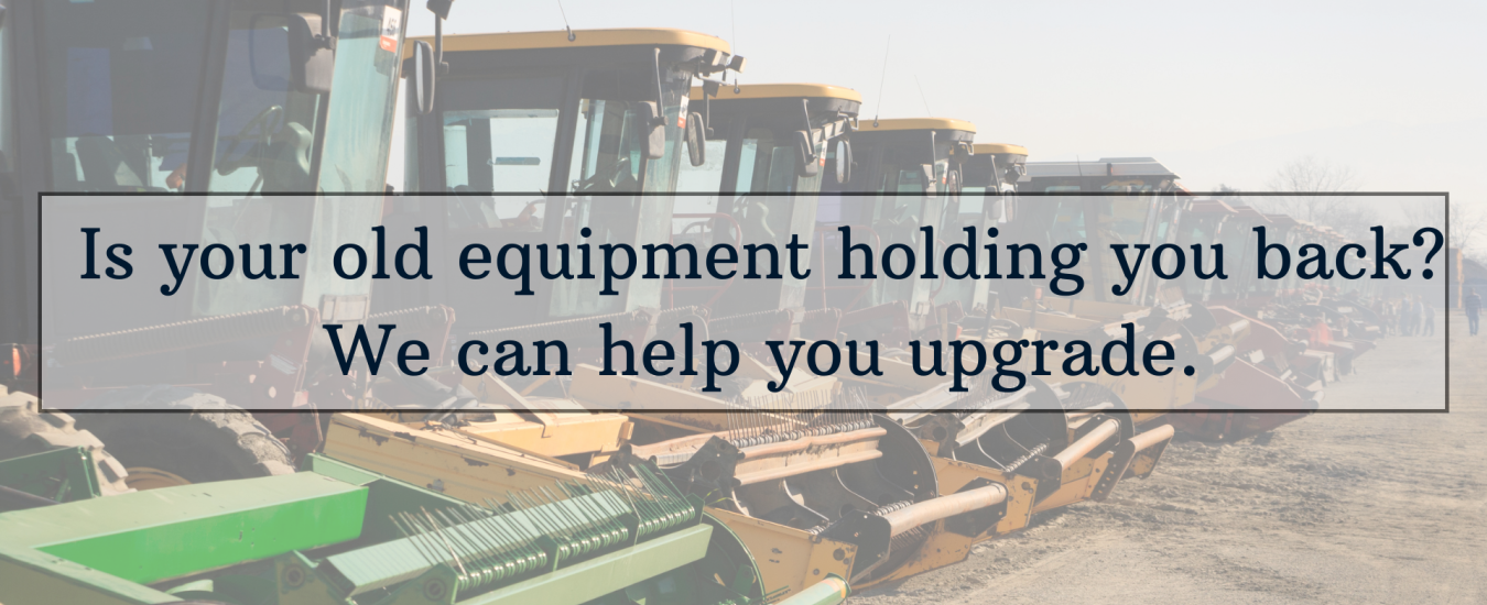 A row of agricultural machinery with a sign saying, "Is your old equipment holding you back? We can help you upgrade.